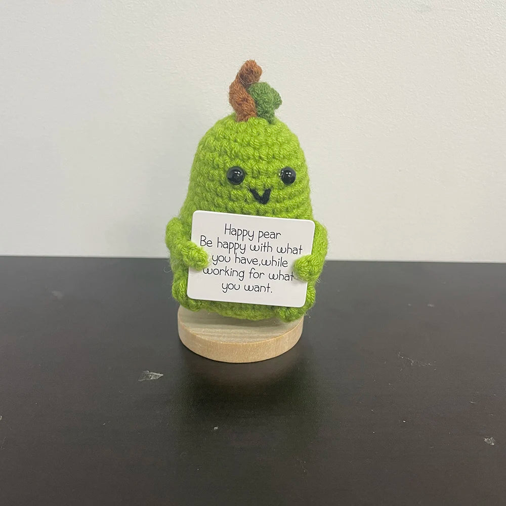 Handmade green crochet pear doll holding an inspirational message about happiness and self-growth, perfect for decor or gifting